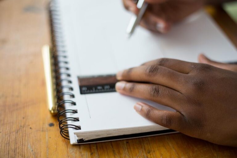 Élève écrivant dans un cahier avec une règle pour le contrôle continu du brevet