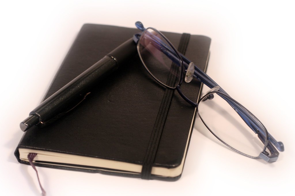Carnet de notes, stylo et lunettes pour organiser le planning de révision du brevet